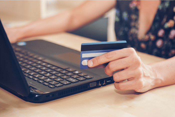 A young woman is purchasing items from the internet using her credit card, depicting e-commerce sales.