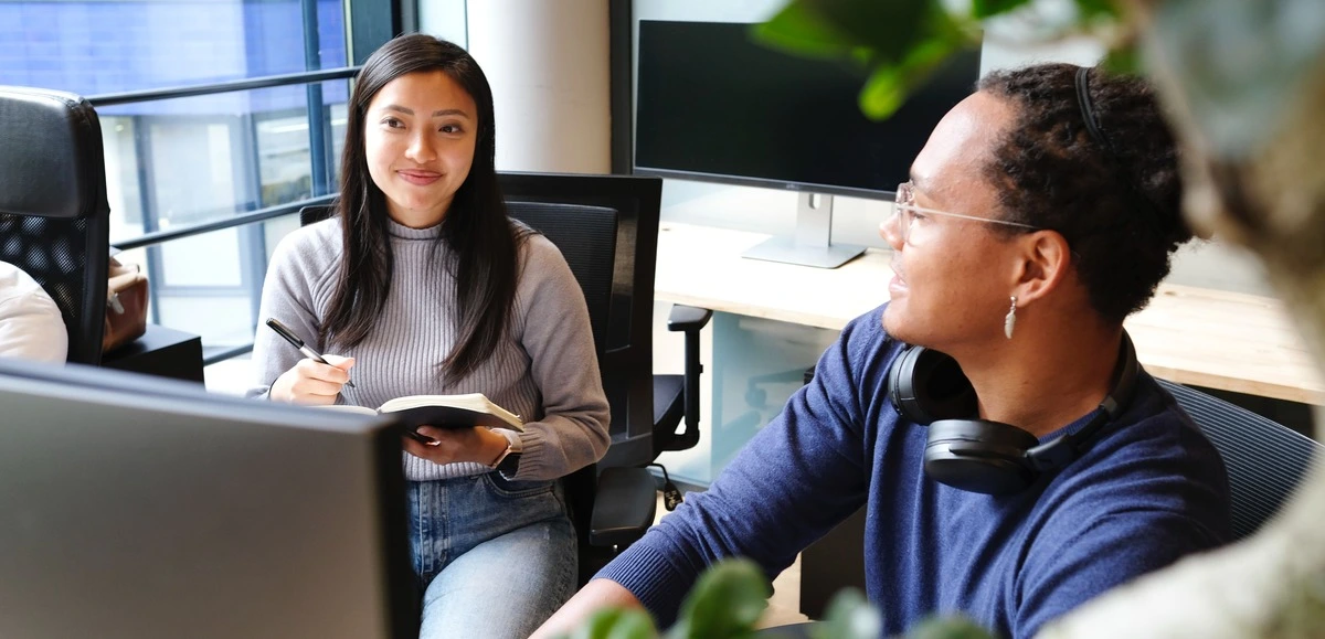 Two customer support service representatives smile at each other