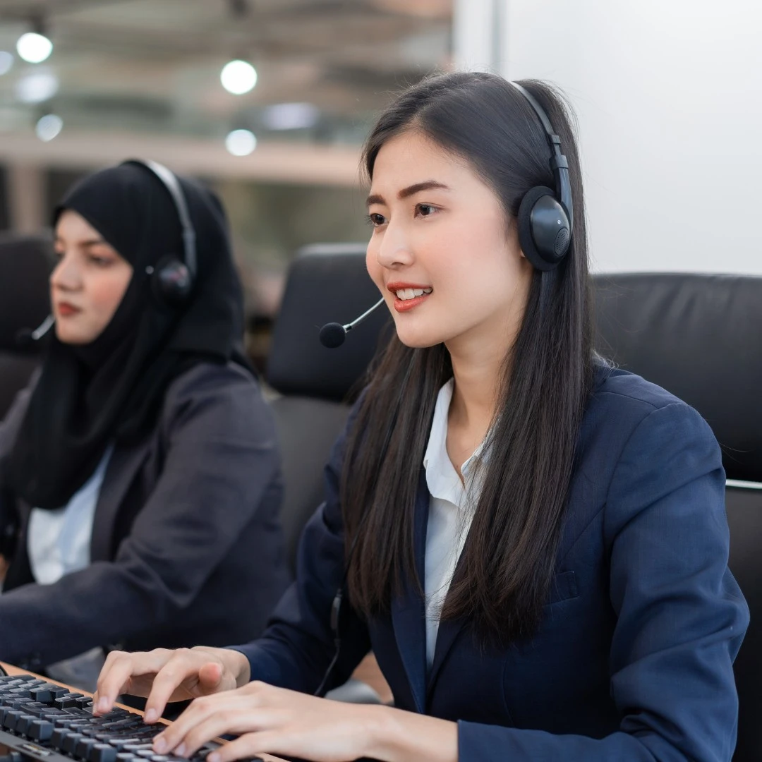 A cheerful customer support agent smiling while working, embodying positivity and readiness to assist.