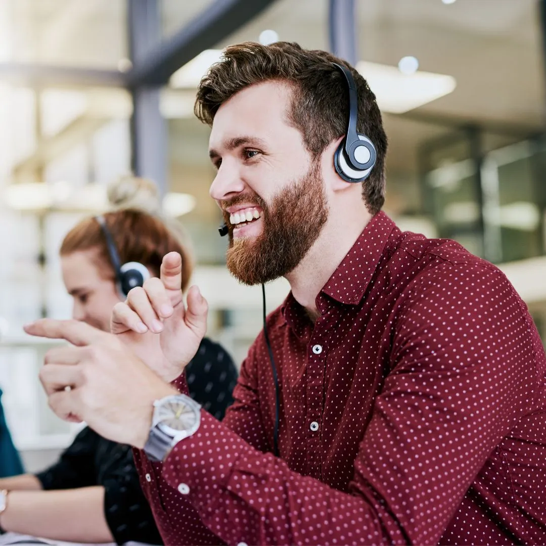 An after hours answering service agent smiling wearing a headset.